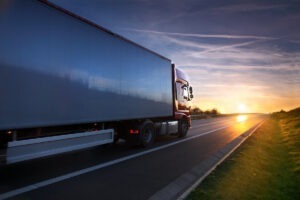 Transporte de camiones en la carretera al atardecer.